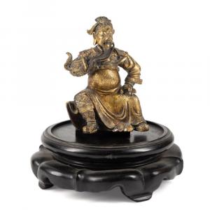 17th or 18th century Chinese gilt bronze figure of Guandi, the god of war, depicted seated and holding his trademark beard with one hand, apparently unmarked, 4 ¼ inches tall ($15,730).