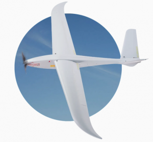 Photo of UKRSPECSYSTEMS' MINI SHARK UAV flying in front of a stylized blue sky circle cut-out.