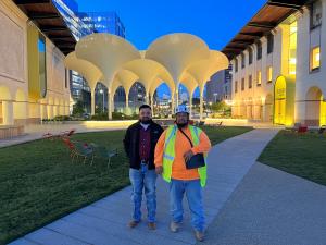 Leads Leonel and Miguel stand in front of the UT Blanton Museum after a successful project.