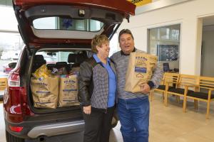 Bess Wills and Bob Avila, Co-Owners of Gresham Ford stand with grocery donations