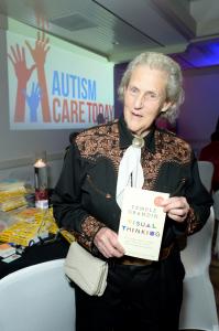 Woman in western gear holding book Visual Thinking with Autism Care Today logo in background