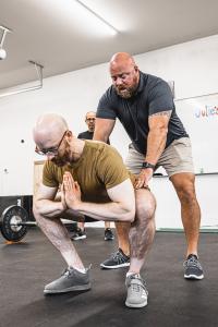 Matt Reynolds coaching a Barbell Logic client in the squat at a recent seminar