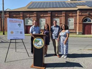 Two men and two women standing outside announcing Kingston Community Solar