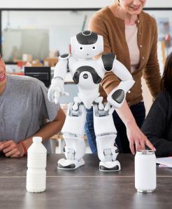 This image shows the NAO robot in a classroom with educators and students