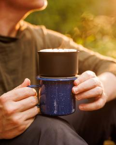 Man using camping pour over outside, zoomed in on pour over