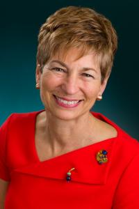 This is an image of Lynne Katzmann with a red dress and short blondish red hair.