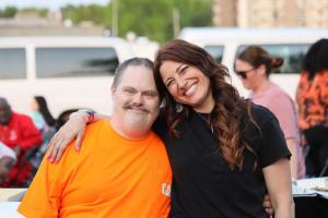 A visitor and a staff member of the Carousel Center pose together for a photo