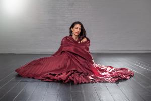 Huma Abedin (seated on the ground draped in a red gown and shawl), host of the 20th annual Moves Power Women Awards Gala & Dinner, courtesy of New York Moves Magazine.