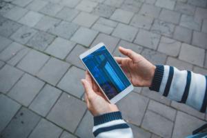 Person holding a cell phone outside.