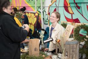 Morgan Holland from Divided Sky Flowers talks with a shopper at the 2022 Kringle Market