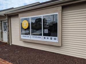 Front view of new office with signage and logo on windows of H.K. Keller Real Estate & Auctions