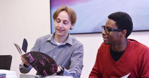Two ArtVersion team members collaborating at a conference table.