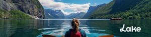 Woman kayaking on a lake with mountains