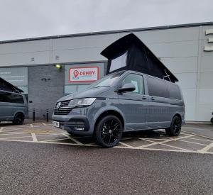 Grey vw campervan with pop top roof open