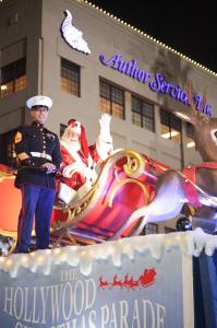 Santa Claus with two Marines on his sleigh in front of Author Services, Inc. as he is about to ride in the Hollywood Christmas Parade.