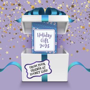 An opened white gift box with a blue bow on a lavender background with shiny confetti falling. Inside the box is a smaller blue box with the label “Holiday Gift 2023.” A label on the outer white box reads “From Your Friends at Looney Labs.”