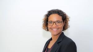 Portrait of a woman with curly brown hair and glasses