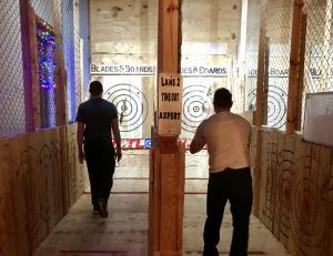 Two men throwing axes at targets.