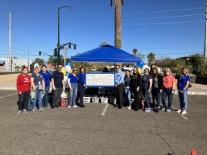 Volunteers and donors pose for a photo during the check presentation