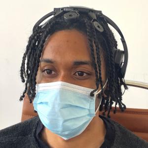 QUASAR's Dry Sensor Interface (DSI) headset worn by a Black person with Braided hair