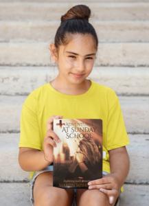 A young girl in a yellow shirt smiling and holding a copy of 'Adventures at Sunday School' by Martin Mishinev, illustrating the book's appeal to young readers.