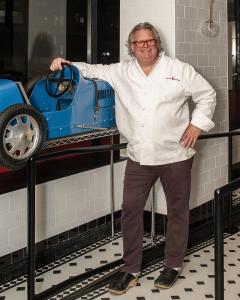 Chef David Burke with the "baby" Bugatti from his electic and extensive art collection in the cafe area of the new Park Ave Kitchen by David Burke.