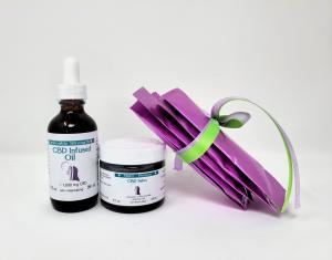 image of a 2 ounce amber bottle of cbd oil, with a dropper, and a two ounce jar of topical salve, also amber, and ten bright individual packets of mushroom coffee with a purple and green ribbon tying them into a bundle