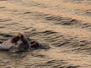 En esta imagen se puede ver a Carlos Acosta nadando entre las olas del mar abierto, con los reflejos de la luz anaranjada del aclarecer, durante uno de los dos amaneceres que pasó nadando.