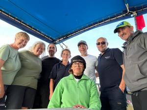 En esta foto se ve el grupo de 7 personas que formaron parte del equipo que acompañó a Carlos Acosta en el barco, durante el cruce doble. El crew, los pilotos, y las observadoras que certifican el logro.