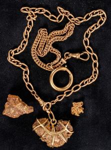 Gold necklace with a gold nugget engraved in gold, “George’s Gulch 1909”; 8.3-gram and 1.7-gram gold nuggets with quartz; and a 12.2-gram gold watch chain ($9,062).