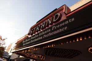 Marquee sign of the Strand Theatre with illuminated lights, displaying 'The Music Studio Atlanta Presents The Strand Destination Performance