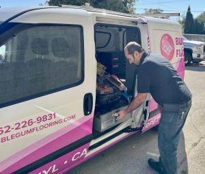 A man in front of a pink Flooring Van