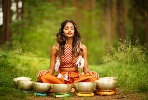 Harmony in Sound: A woman surrounded by Himalayan sound bowls, immersed in the healing vibrations of a solfeggio frequency sound bath, exemplifies the power of sound in aligning and rejuvenating the spirit.