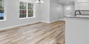 View of a living room with a window and wood floor.
