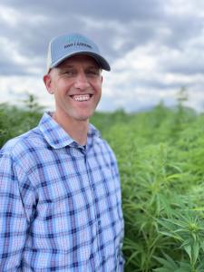 NWG CTO Dr. Rich Fletcher poses in front of a research plot of AMPLIFY hybrid admiring years of successful breeding selections and genomic testing.