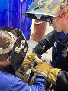 Student holding welding equipment and learning how to weld.