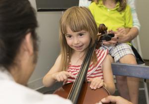 Little girl seated with cello