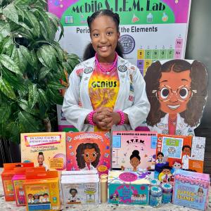 Ava N. Simmons is standing with her STEM Toy Line