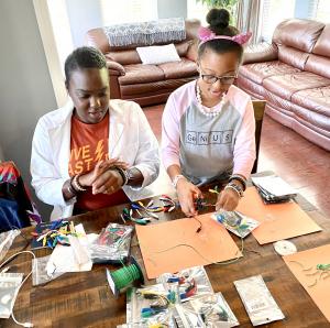 Ava N. Simmons standing at a table making her first STEM experiment kit with her sister Chynah Jeter in 2021