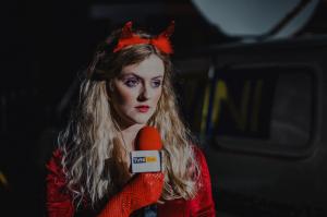 Michelle Kelly dressed in a devil costume speaks into a TVNI microphone
