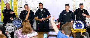 Modesto PD police officers interacting with students in a classroom.