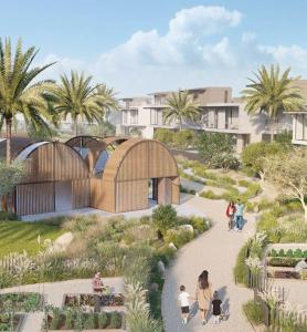 residents walk through green communal farming area with greenhouse and villas in background