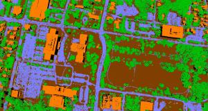 Classified point cloud with trees in green, buildings in orange, ground points in brown, and the ground subclass of roads in purple.