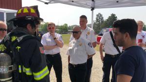 firefighter on the left speaking to Ascent CEO, Paul Couston, in front of fire chiefs