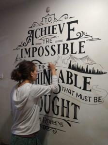 Jen Flanagan paints a work in progress mural at a cafe in Kathmandu, frequented by travelers about to hike the Himalayas