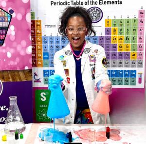 Ava is holding lab glassware with colorful foam splashing out from the acid base reaction