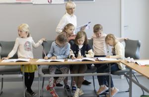 Teacher Svitlana Mulka (behind) with children from the program