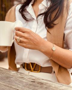Woman modeling gold-tone medallion bracelet and ring with mother-of-pearl inlay