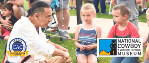 A karate coach talking to three young kids in a park.