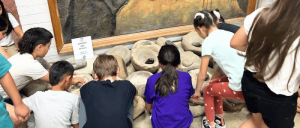 Staff of Tulare County Museum catering to a group of children inside the museum.